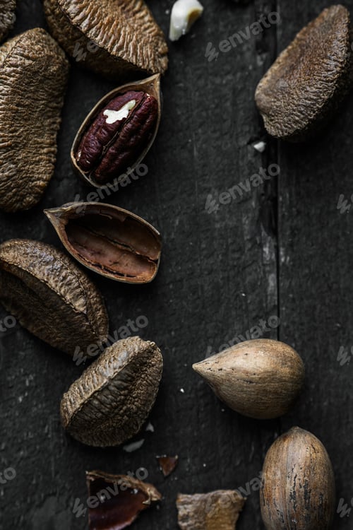 Preview: Raw Brazil and Pecan nuts in shell on Wooden Rustic table.