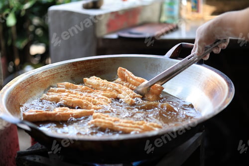 Preview: Man Hand Fried Chinese Deep Fried Dough Stick or Youtiao in Big Pan