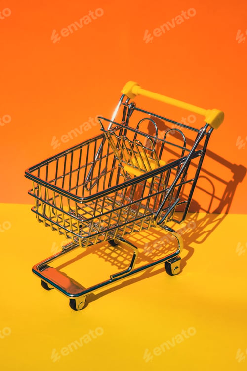 Preview: Empty shopping trolley cart on colorful orange yellow background. Copy space for your text. Online