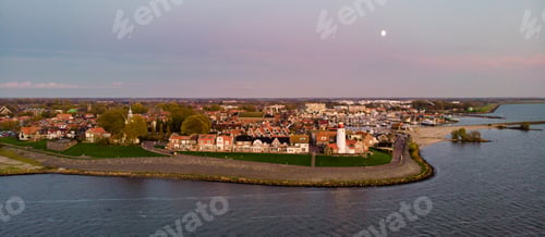 Preview: Urk Flevoland Netherlands sunset at the lighthouse and harbor of Urk Holland. Fishing village Urk