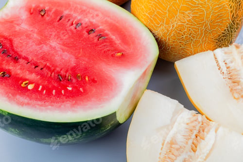 Preview: close-up view of pattern of cut and whole fruits as watermelon and melon on bluish gray background