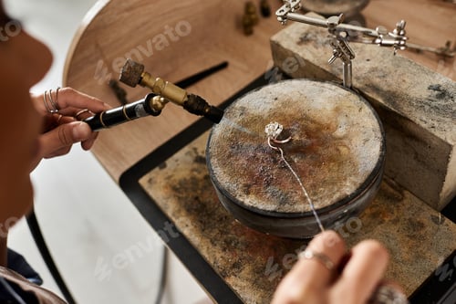 Preview: A skilled artisan delicately crafting intricate jewelry with precision and care in a cozy workspace