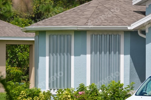 Preview: Hurricane shutters made from steel mounted for protection of house windows.