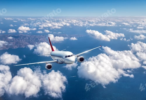 Preview: Airplane is flying above the clouds at sunset in summer