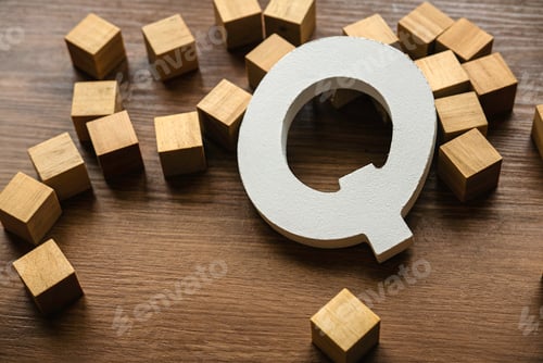 Preview: Wooden letter Q on a brown wooden background.