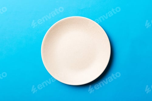 Preview: Top view of isolated of colored background empty round beige plate for food