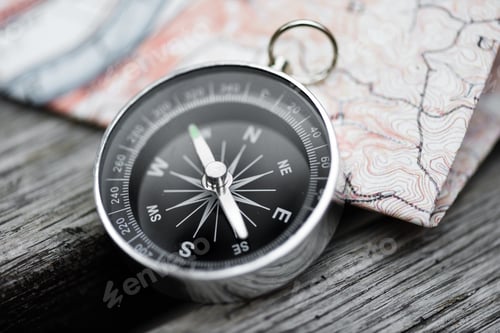 Preview: Compass and map on a beautiful wooden surface. Top view