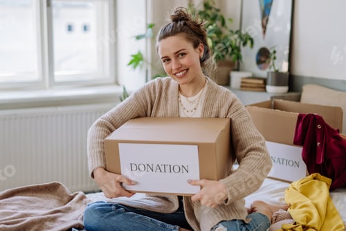 Preview: Young woman giving her clothes to charity.
