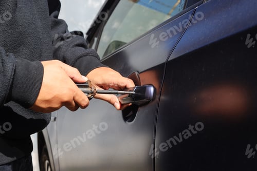 Preview: Auto thief trying to break into car with screwdriver.