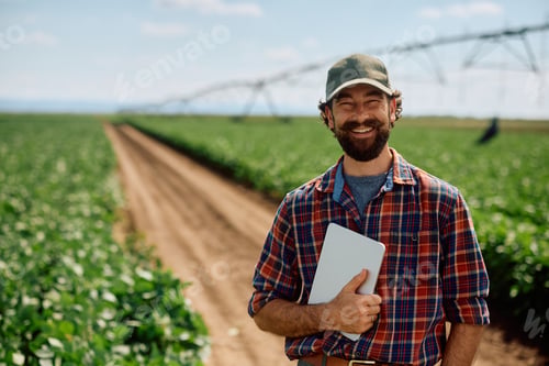 Preview: Portrait of happy agronomist with digital tablet at his farm looking at camera.