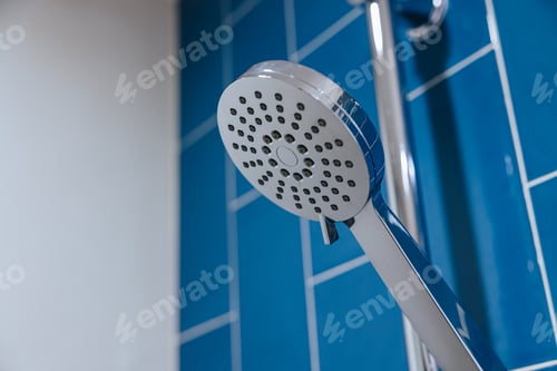 Visualização: Closeup Clean New Chrome Shiny Dry Head em fundo de parede azul do banheiro