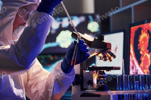 Preview: Scientist in white protective uniform near displays with data works with coronavirus