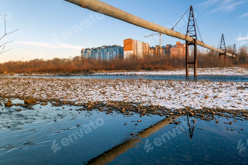Preview: Gas or water pipe over the river and residential buildings behind