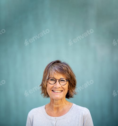 Preview: Close up woman in 50s smiling by green background