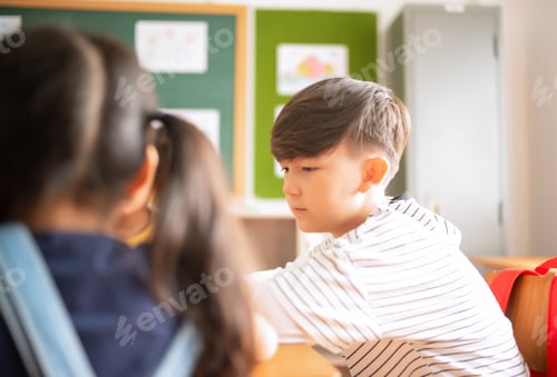 Visualização: Menino de escola caucasiano senta em cadeiras e estuda com amigos juntos na sala de aula do ensino fundamental