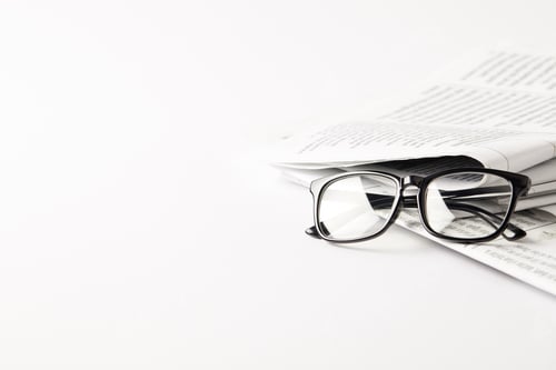 Preview: pile of newspapers with eyeglasses, on white background with copy space
