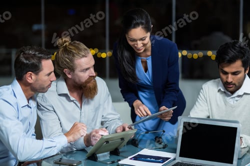 Preview: Businesswoman Discussing With Colleagues Over Digital Tablet In The Office
