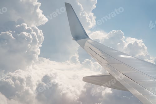 Preview: Wing of a white plane aircraft in the sky with white clouds