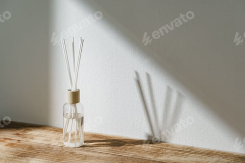 Preview: Sunlit Diffuser Bottle With Reeds Casting Shadows on a White Wall