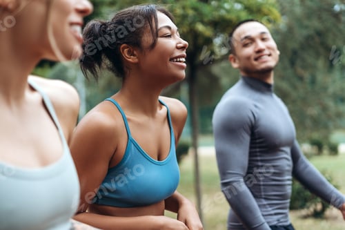 Preview: African American woman talking with diverse sportswoman and Asian man, walking, training together