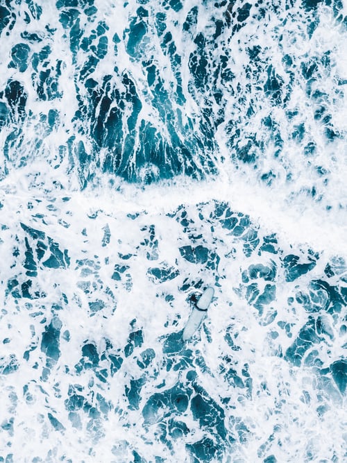 Preview: Vertical shot of ocean waters with waves making white foam