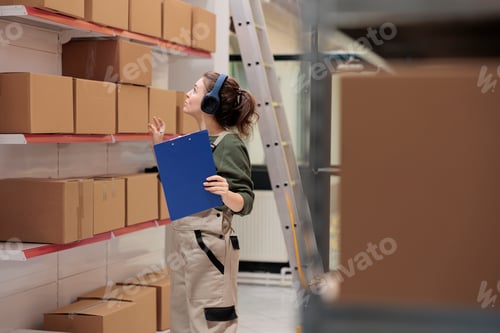 Preview: Worker looking at carton boxes checking shipping details