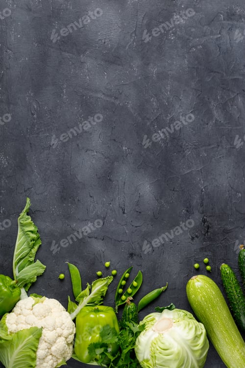 Preview: Border of organic green raw vegetables on black table. Top view of healthy organic food. Copy space