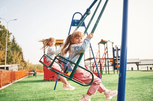 Preview: Enjoying swing ride. Kids are having fun on the playground