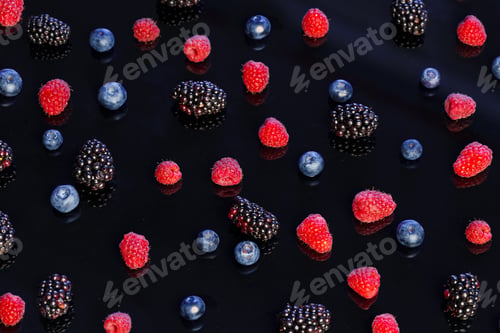 Vista previa: Fresh wild berries scattered on black background