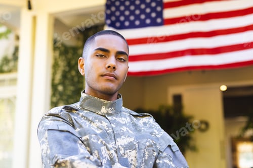 Preview: Portrait of biracial male american soldier wearing military uniform standing outside the house