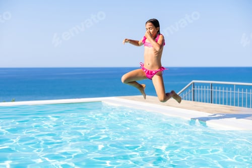 Preview: Closeup portrait of cute little arabic girl swimming in the pool, happy child having fun in water