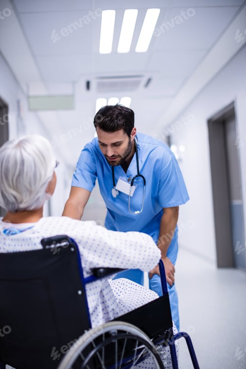 Preview: Male doctor interacting with senior patient on wheelchair