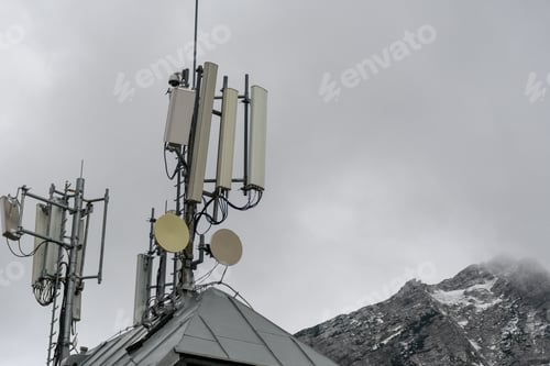 Preview: View of mobile network antennas and repeaters on the roof of a mountain lodge