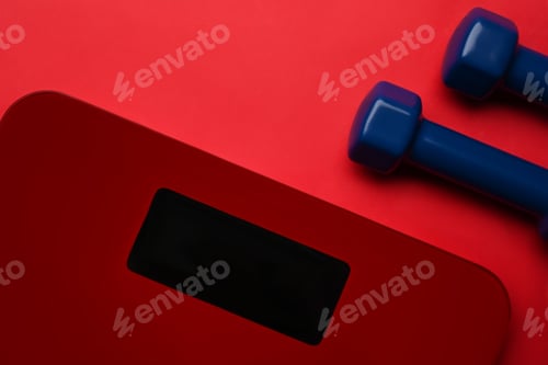 Preview: Digital scales and dumbbells on red background. Loosing weight and healthy lifestyle concept.
