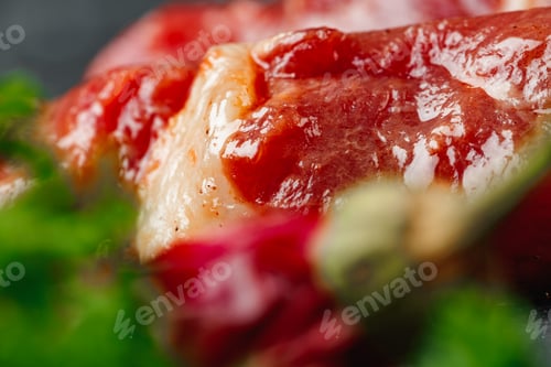 Preview: Raw beef kebab with herbs on a dark board