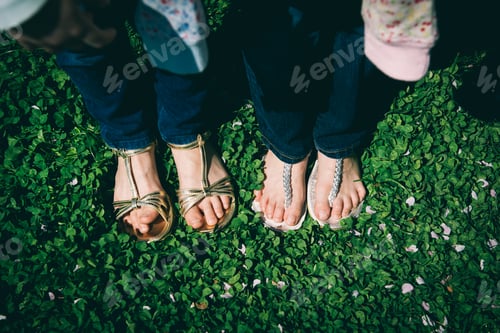 Preview: Two young girls with summer sandals on grass