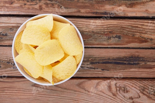 Preview: Potato chips on a wooden surface in a saucer