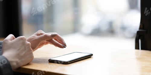 Preview: Woman holding phone with blank screen in hand on street view from window background