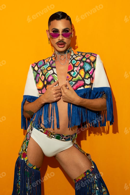 Preview: Portrait of a young drag queen in colorful dress on yellow background