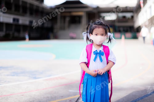 Preview: Child back to school concept. Girl wearing cloth face mask. Kid shoulder pink bag.