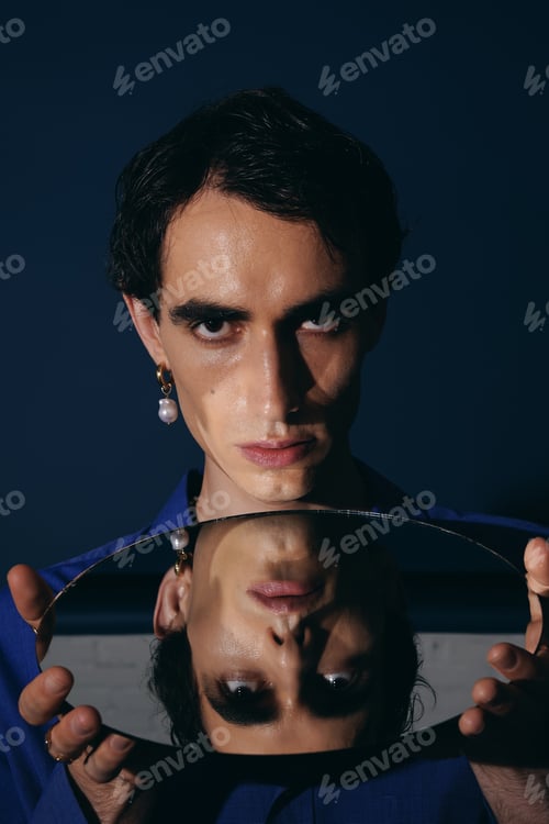 Preview: Stylish man captures attention with striking gaze and elegant attire in a serene setting