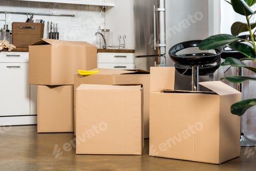 Preview: interior of modern kitchen with cardboard boxes during relocation at new home
