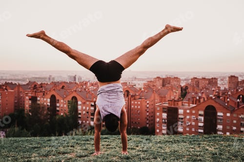 Preview: latino young man in a park practicing yoga sport. city background. healthy lifestyle.
