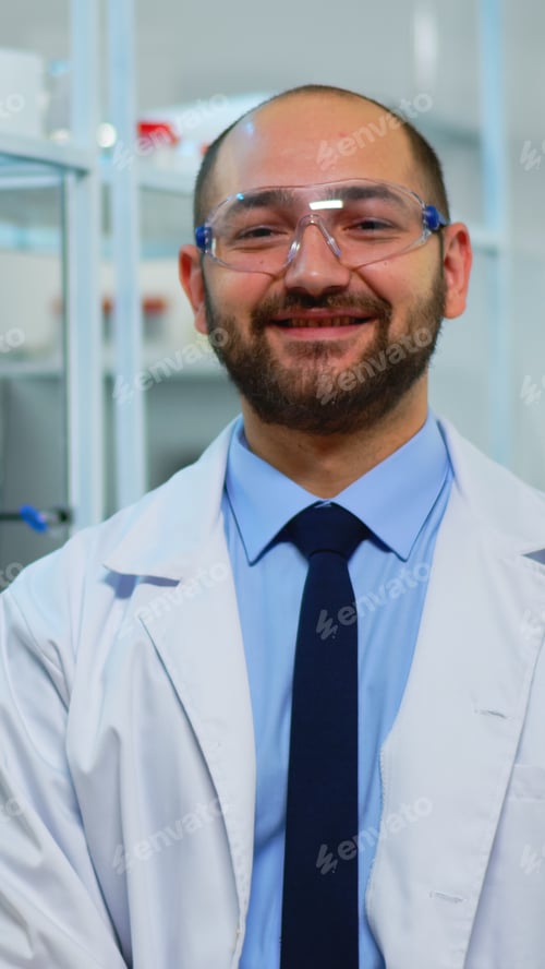 Preview: Microbiologist sitting in laboratory looking at camera