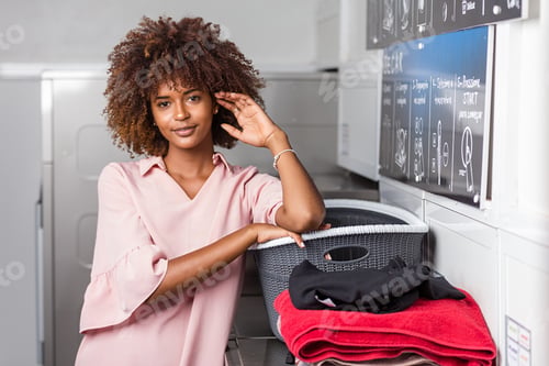 Preview: Young black African American woman washing her clothes in a auto
