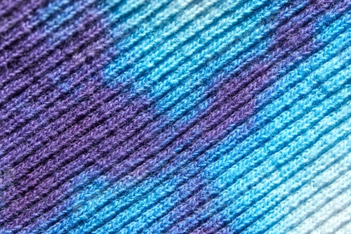 Preview: Close up of colorful stitched wool fabric in shades of blue and purple