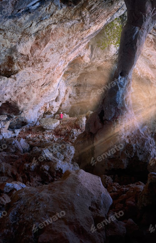 Preview: Adventurous hiker exploring the beautiful rocky caves of the mountain