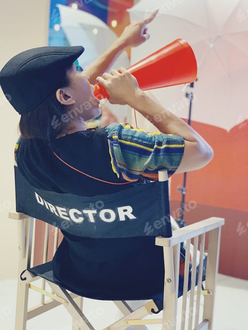 Preview: Woman in director chair in a film set directing the crew