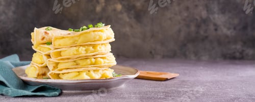 Preview: Kystyby - a thin flatbread filled with mashed potatoes and onions on a plate. Web banner