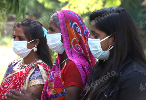 Preview: Closeup of three Indian women wearing facemasks, standing outdoors